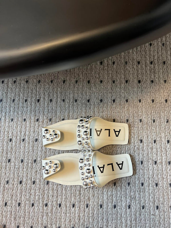 ALAIA FOLDED FLAT MULES WITH SPHERES ON WHITE CALFSKIN