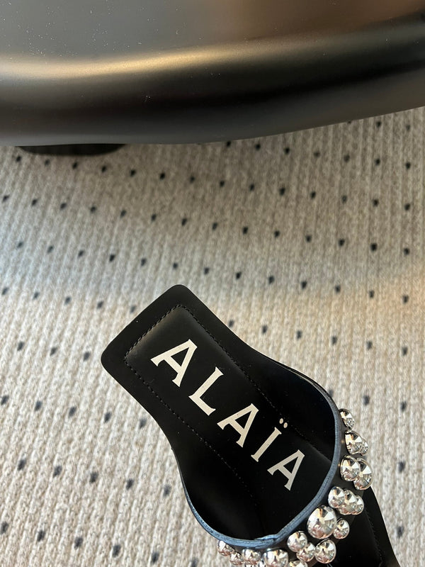 ALAIA FOLDED FLAT MULES WITH SPHERES ON BLACK CALFSKIN