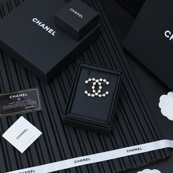 DOUBLE C LETTER BROOCH IN GOLD METAL WITH CRYSTALS AROUND LOGO