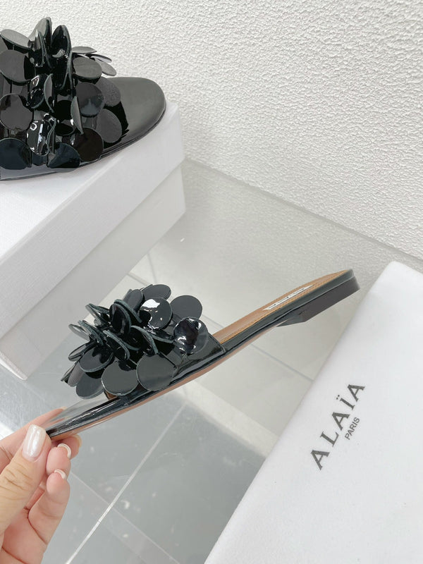 ALAIA FLAT MULE IN BLACK GLOSSY LAMBSKIN