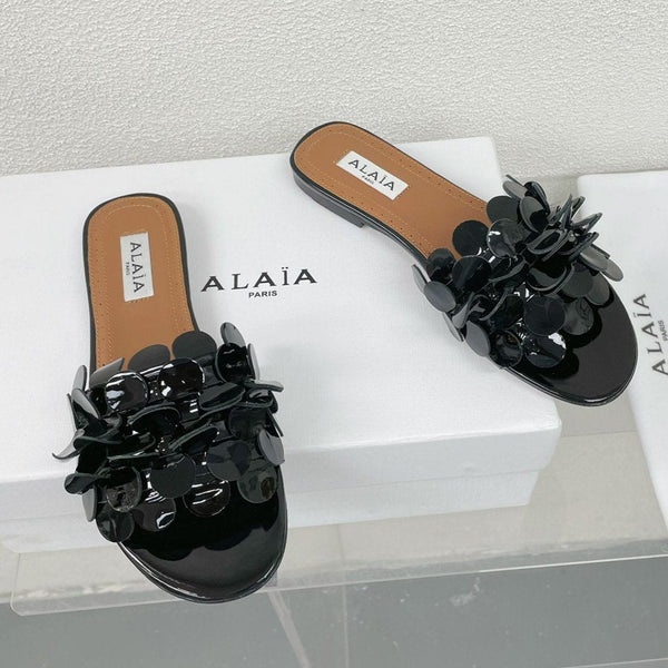 ALAIA FLAT MULE IN BLACK GLOSSY LAMBSKIN
