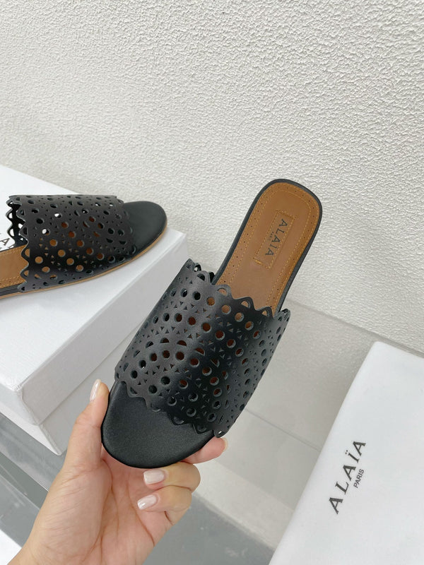 ALAIA VIENNE FLAT MULES IN BLACK LAMBSKIN