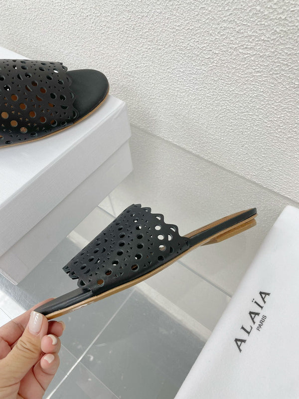 ALAIA VIENNE FLAT MULES IN BLACK LAMBSKIN