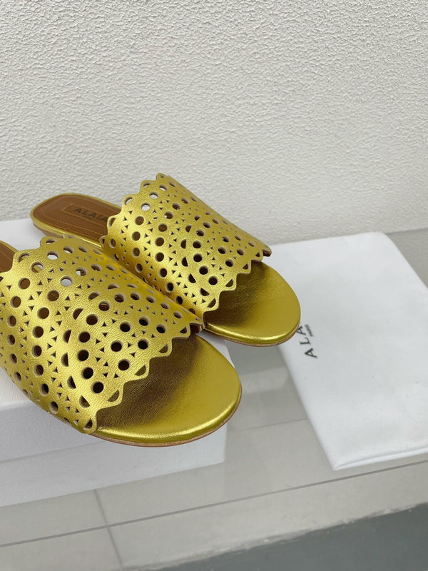 ALAIA VIENNE FLAT MULES IN GOLDEN LAMBSKIN