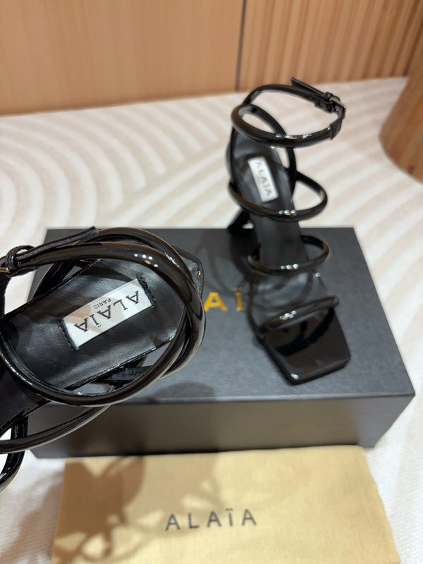 ALAIA THREE-STRAPS HIGH HEEL SANDALS IN BLACK PATENT LAMBSKIN