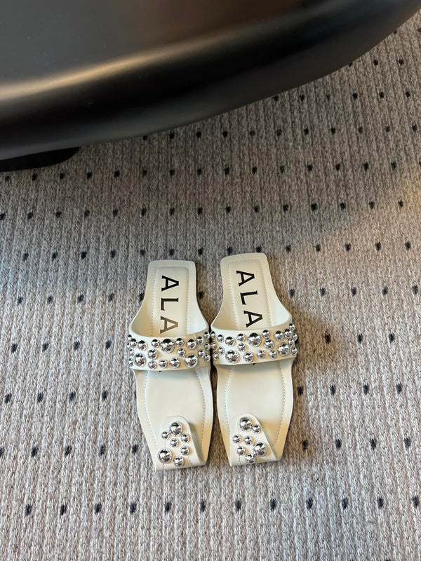 ALAIA FOLDED FLAT MULES WITH SPHERES ON WHITE CALFSKIN