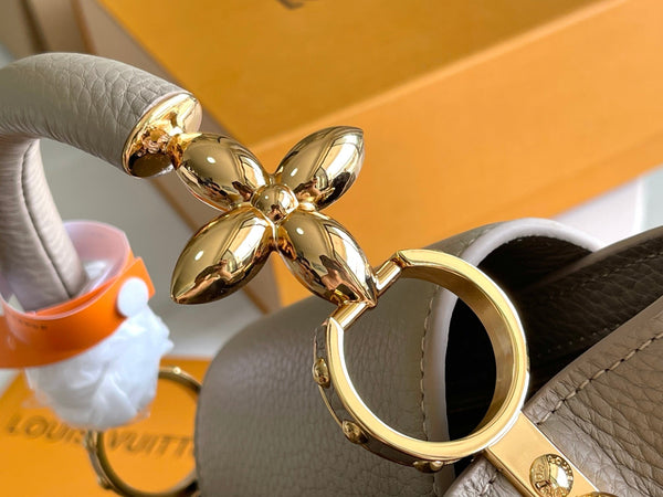 CAPUCINES BB 27 DARK BEIGE TAURILLON GOLD HARDWARE